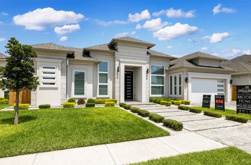 Modern single-story home with a landscaped front yard, featuring a stylish entrance and decorative shrubs.