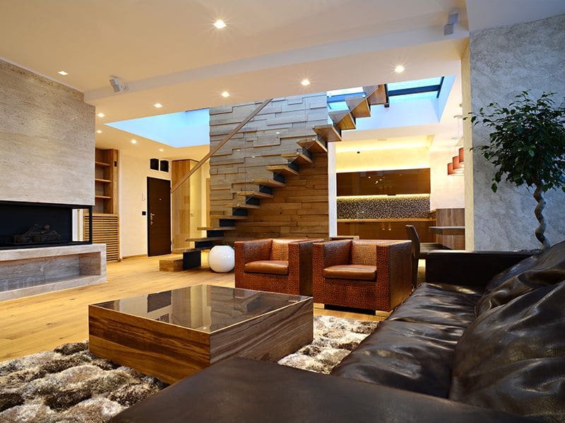 Luxury living room interior with stairs and mixed materials in walls