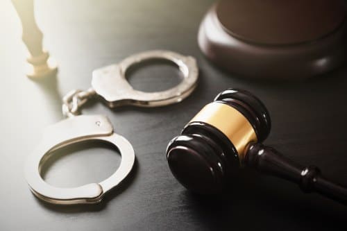 Handcuffs and wooden gavel. 