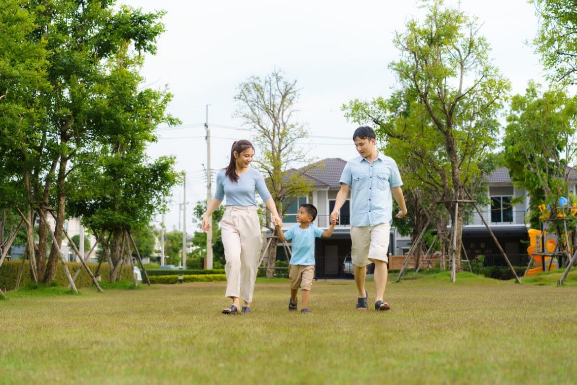 Asian family walking in yard or public park in neighborhood for daily health and well being, both physical and mental happy family.