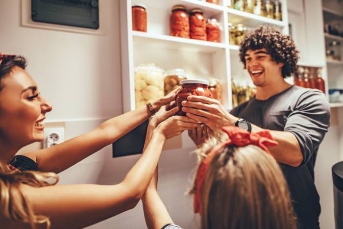 Group of friends entertained in kitchen